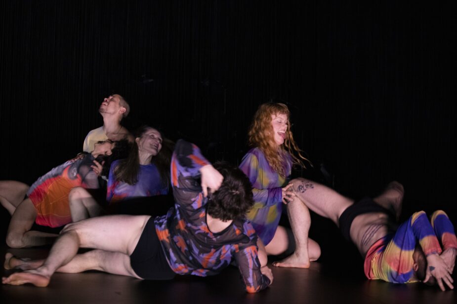 Several dancers in a stack on a stage