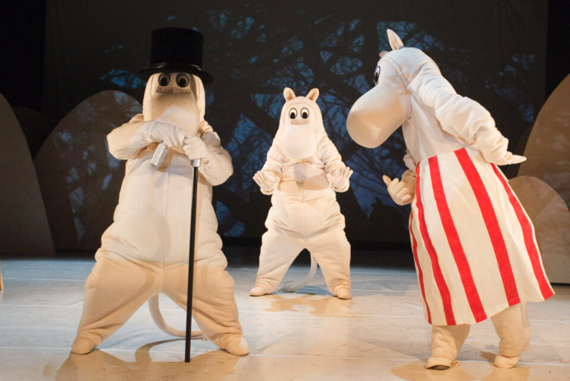 Muumipappa, Muumipeikko ja Niiskuneiti lastenesityksen näyttämöllä.