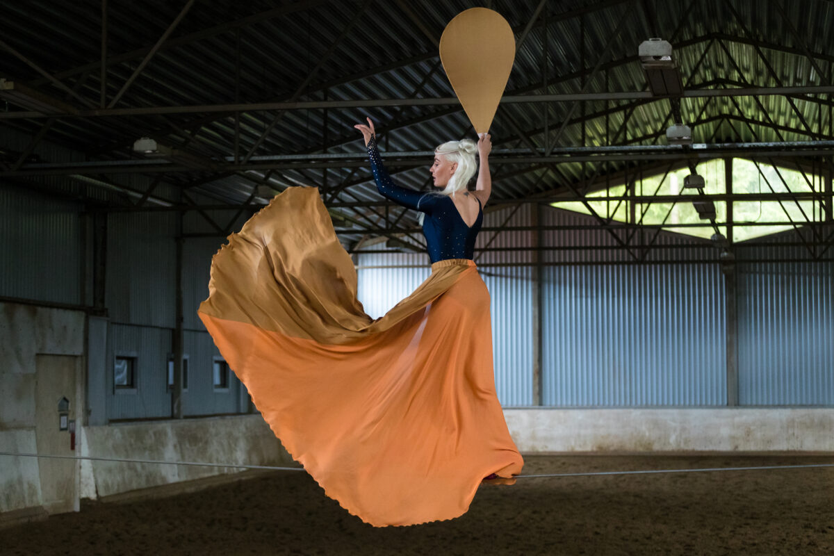 Nuorallatanssija oranssissa, liehuvassa hameessaan.